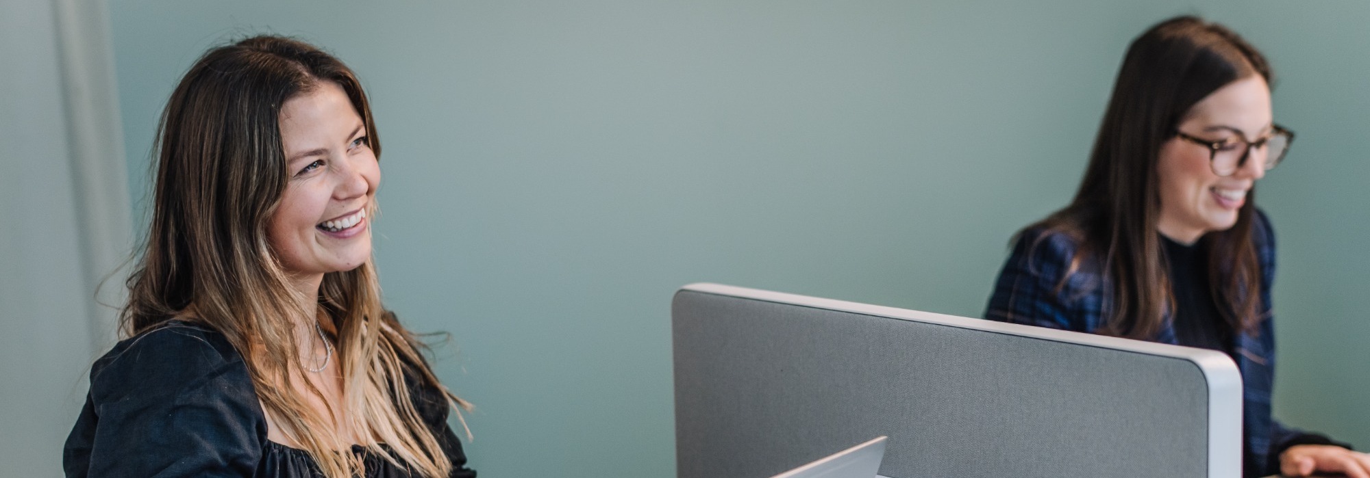 Sharp & Carter Specialist Recruitment, Our Method, Female Worker Smiling at Desk