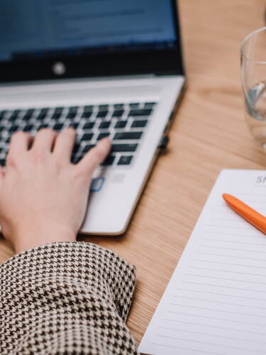 Sharp & Carter Specialist Recruitment, News & Insights, Working on Laptop with Notepad